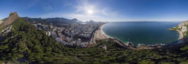 Ön planda Rio de Janeiro'da Two Brothers dağ ve Leblon plaj ve mahalle Sunrise 360 derece tam panoramik hava görünümü ve arka planda Rio geniş şehir manzarası