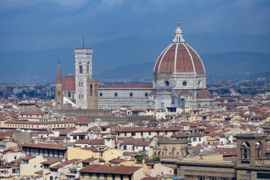 Floransa mavi sisli gökyüzüne karşı şehrin çatıları üzerinde yükselen merkezi katedral duomo ile uzaktan görüldü