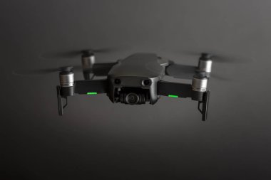 Rio de Janeiro, Brezilya - 2 Ağustos 2019: Dönen pervaneler ve yeşil konumlandırma ışıkları ile uçuşta bir drone'un gri stüdyo arka planına karşı ön görünümü