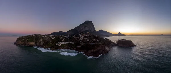 Güzel pitoresk doğal zenginliği ve arka planda çok gün tatilinde şehrin iyi bilinen simgesel zirveleri ile Rio de Janeiro'da Joatinga sahil şeridi ve plaj Panoramik görünümü