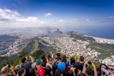 Rio de Janeiro, Brezilya - 13 Temmuz 2017: Rio de Janeiro'nun nefes kesen ikonik manzarasının parlak güneşli bir günde fotoğraflarını çeken Corcovado dağının tepesindeki turist kalabalığı