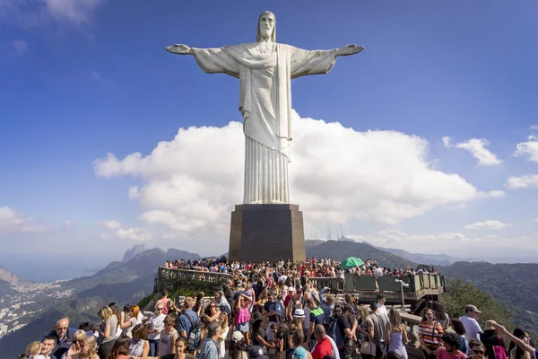 Rio de Janeiro, Brezilya - 13 Temmuz 2017: Rio de Janeiro'daki Corcovado dağının tepesinde bir turist kalabalığının açık görünümü, üzerlerinde yükselen Mesih heykeli ve mavi bir gökyüzünde bir bulut