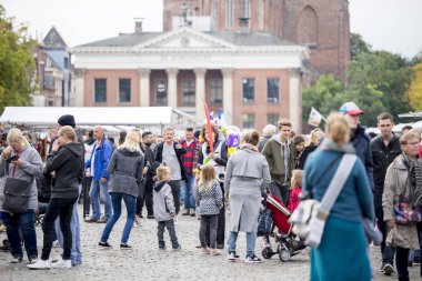 Groningen, Hollanda - 1 Ekim 2016: Groningen'de cumartesi sabahı pazarı bulutlu bir günde kalabalığın ortasında balon hayvan satan genç bir adam