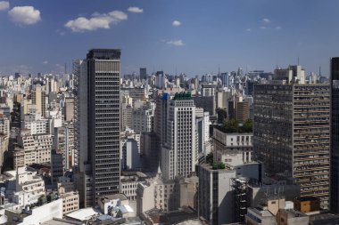 Sao Paulo'da bulutlarla dolu mavi bir gökyüzüne karşı görebileceğiniz kadarıyla gökdelenlerin yüksek görüş noktasından şehir manzarası