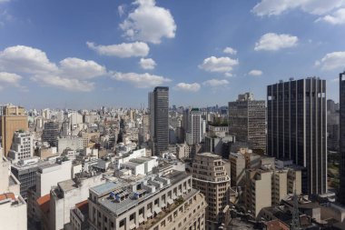 Sao Paulo'da bulutlarla dolu mavi bir gökyüzüne karşı görebileceğiniz kadarıyla gökdelenlerin yüksek görüş noktasından şehir manzarası