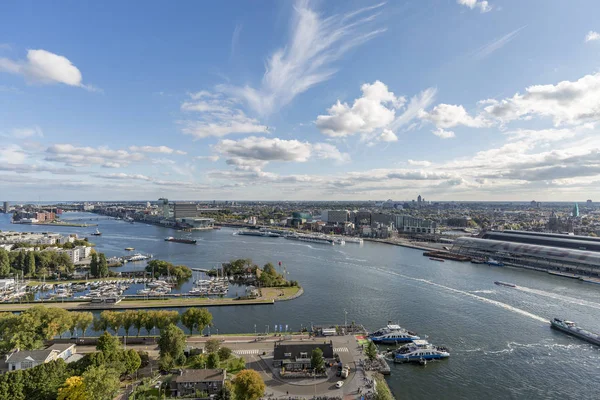 Ön planda feribot ile Amsterdam liman alanı arkasında bir yelkenli liman ve şehir ve Ij nehri üzerinden geçen gelen ve giden kargo gemileri