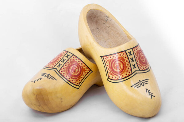 Съемка голландской деревянной обуви крупным планом, типичной для традиционной деревенской одежды в Нидерландах, в настоящее время в основном сувенир на белом фоне
