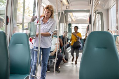 Rotterdam, Hollanda - 28 Ağustos 2019: Tramvaydaki kadın, toplu taşıma aracına binip inen ve giden ödeme sistemini kullanıyor