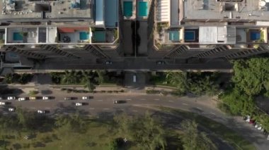 Binaların arkasındaki havuz ve tenis kortlarını ve havuz kenarlarını gösteren yüksek katlı apartman kompleksinin yukarıdan aşağıya bakan görüntüsü.