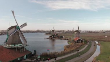 Zaanse Schans yel değirmenleri üzerinde mavi gökyüzü ile parlak bir günde dönen fitiller ile tipik bir Hollanda manzara havadan görünümü
