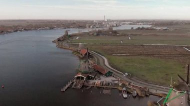 Arka planda mavi gökyüzü ve diğer yel değirmenleri ile parlak bir günde dönen fitiller ile tipik bir Hollanda manzara ön planda bir yel değirmeni üzerinde kaydırma