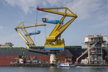 Amsterdam, The Netherlands - August 31, 2019: Large yellow industrial cranes next to a seafarer ship