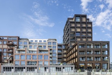 Amsterdam, Hollanda - 31 Ağustos 2019: Yeni inşa edilen Houthaven Mahallesi 'nde mavi gökyüzüne karşı farklı stiller ve bulut izleri ile çağdaş konut mimarisi