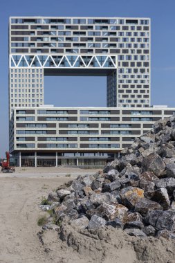 Amsterdam, Hollanda - 31 Ağustos 2019: Houthaven semtinde önünde bir yığın kaya bulunan çağdaş konut projesinde modern apartman ın mimarisi
