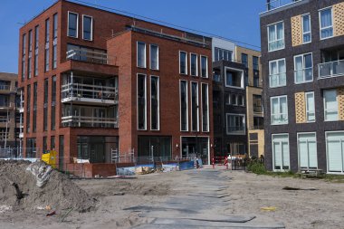 Amsterdam, Hollanda - 31 Ağustos 2019: Yeni inşa edilen Houthaven Mahallesi 'ndeki modern mimari destekleyici ağır plakalarla birlikte evler inşa ediliyor