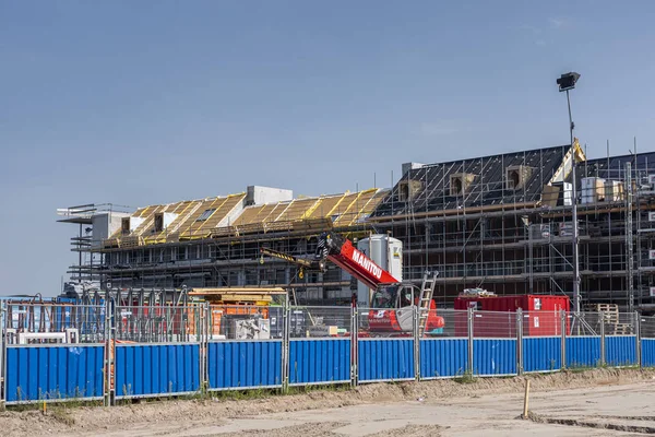 Amsterdam, The Netherlands - August 31, 2019: Modern sustainable housing in the port area of Houthaven neighbourhood with construction tools in the foreground and homes in scaffolding in the back