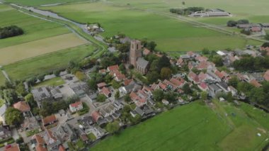 Aerial approach of the village of Ransdorp with its agrarian surroundings just outside of Amsterdam in The Netherlands against a blue sky with clouds
