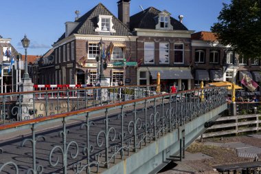 Muiden, Hollanda - 2 Eylül 2019: Arka planda geleneksel Hollanda konutları bulunan teknelerin limandan iç kesimlere geçmesine izin veren dönen kapak köprüsü