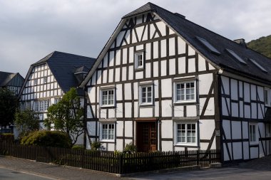 Gün batımında Almanya 'nın Sauerland bölgesindeki Grafschaft adlı spa köyündeki tipik yarı keresteli Vakwerk evlerinin mimarisi.