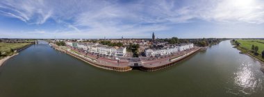 Geniş 180 derece Zübeyde Hanseatic Hollanda kenti panoramik görünümü. Yerleşim yüzleri gibi beyaz evler ile mavi bir gökyüzüne karşı geçen nehir Ijssel ile ortaçağ kasabasının Cityscape