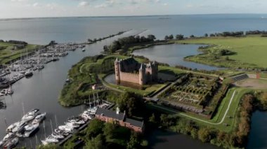 Amsterdam yakınlarındaki Muiden 'daki Muiderslot şatosunu gösteren hava yatağı, arka planda Ijsselmeer ile ön plandaki ağaçlar tarafından gizlenmiş.