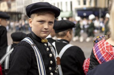 Lahey, Hollanda - 17 Eylül 2019: Prinsjesdag'daki geleneksel çiftçi giyiminde genç çocuk, at ve at arabasının altın koçunun önünden geçen Hollanda kral ve kraliçesini bekliyor
