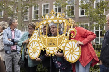 Lahey, Hollanda - 17 Eylül 2019: Hollanda kral ve kraliçesinin Den Haag'daki Prinsjesdag'taki altın vagonda geçmesini beklerken kağıt koçlarıyla poz veren insanlar