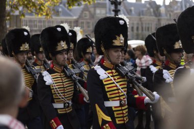 Lahey, Hollanda - 17 Eylül 2019: Hollanda kral ve kraliçesi arkasında parlamento binası ile Prinsjesdag altın otobüs geçen önce geleneksel üniformalı askeri geçit töreni