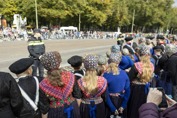 Lahey, Hollanda - 17 Eylül 2019: Geleneksel giysiler içindeki genç kızlar, Prinsjesdag 'da altın koçla geçen Hollanda kral, kraliçesi ve kraliyet ailesini bekliyorlar