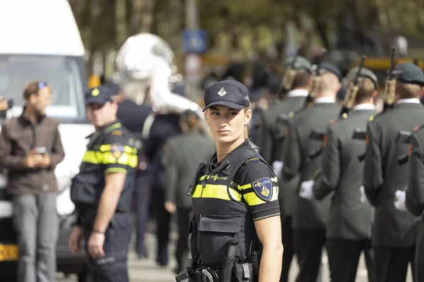 Lahey, Hollanda - 17 Eylül 2019: Den Haag'daki Prinsjesdag'ta askeri geçit töreninin geçtiği yolu koruyan kadın polis memuru