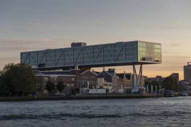 Rotterdam, Hollanda - 20 Eylül 2019: Unilever modern ofis binası, altın saat gün batımında arka planda modern şehir ile eski geleneksel ev ve ofisler üzerine inşa