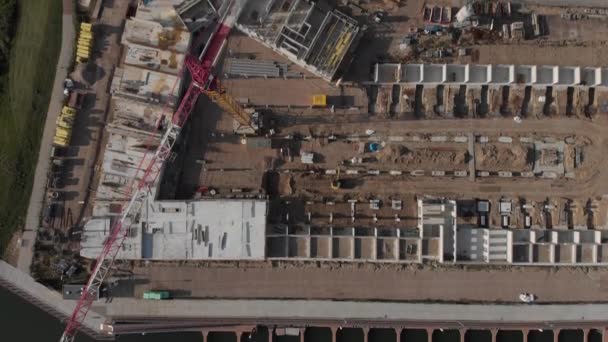 Vue aérienne du haut vers le bas sur un chantier de construction dans le nouveau quartier Noorderhaven dans la ville de Zutphen, Pays-Bas, avec des équipements lourds et un premier niveau de bâtiments résidentiels 