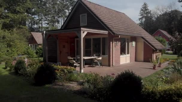 Aerial backing off of summerhouse in The Netherlands with garden roof and terrace in natural and green surrounding revealing the greenery in shade in the foreground against a blue sky — Stock Footage Aerial Backing Summerhouse Netherlands Garden Roof Terrace Natural Green Surrounding Royalty Free Stock Footage