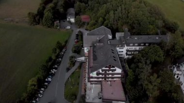 Winterberg yakınlarındaki Sauerland bölgesindeki Grafschaft 'ın kaplıca ve kayak köyündeki Alpin otelinin hava manzarası bulutlu mavi bir gökyüzüne karşıdır.