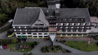 Winterberg yakınlarındaki Sauerland bölgesindeki Grafschaft 'ın kaplıca ve kayak köyündeki Alpin otelinin hava manzarası bulutlu mavi bir gökyüzüne karşıdır.