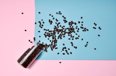 Kahve çekirdekleri nane mavisi arka planda kristal bir kavanozdan dökülüyor. Pastel renkli duvar kağıdı, moda fotoğrafçılığı