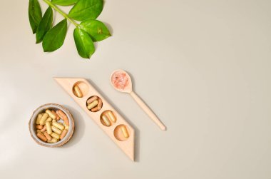 Vücut ve yüz bakımı için kaplıca ürünleri, çeşitli spa tedavisiyle ilgili yukarıdan görüş, mesaj için boş alan. Kapsüllü haplar ahşap kasede, pembe deniz tuzu