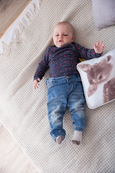 Sério bebê menina deitada na cama e olhando para cima — Fotografia de Stock