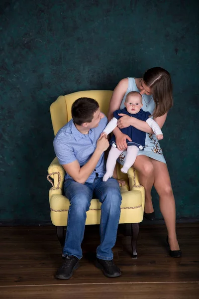 Famiglia caucasica in posa su una grande poltrona in studio — Foto Stock