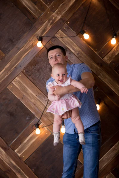 Padre sosteniendo pequeña hija en el aire en el estudio —  Fotos de Stock