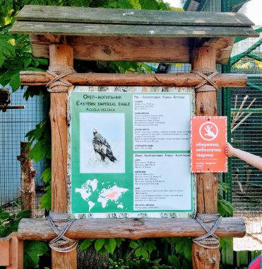 Doğu İmparatorluğu kartalının bilgileri, Ukrayna, Kyiv hayvanat bahçesindeki ahşap bilgi panosunda.