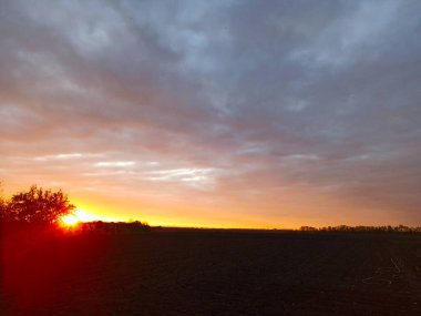 Kırsal bölgedeki tarım arazisinin üzerinde güzel bir günbatımı.