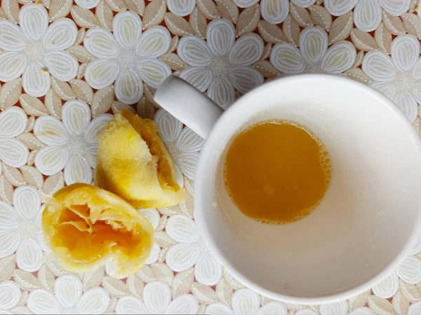 レモンスライスとテーブルクロス付きテーブルの上にレモンジュースとカップのトップビュー — ストック写真