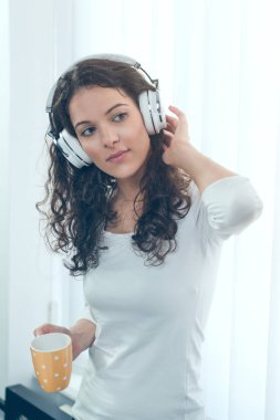 Onun fincan kahve zevk ve müzik dinleme genç kadın