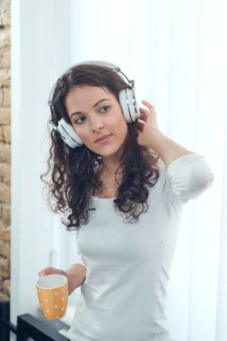 Onun fincan çay zevk ve müzik dinleme genç kadın