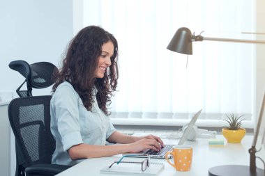 Ofisinde not defteri olan genç ve güzel bir iş kadını.