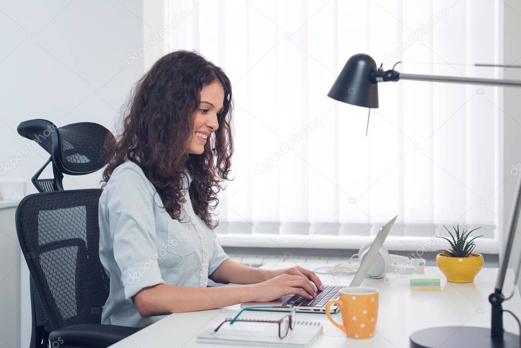 Young pretty business woman with notebook in the office