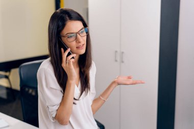 İş iletişimi. Bir telefon olan genç iş kadını.