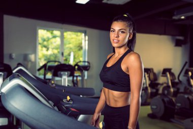 Spor salonunda çalışan genç bir kadın sağlıklı bir hayat sürüyor.