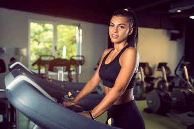 Spor salonunda çalışan genç bir kadın sağlıklı bir hayat sürüyor.